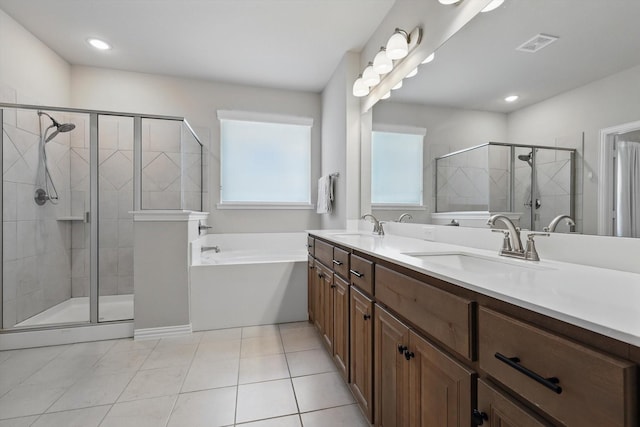 bathroom featuring a healthy amount of sunlight, a stall shower, and a sink