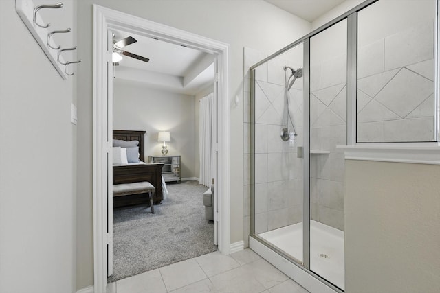 ensuite bathroom featuring a stall shower, baseboards, a ceiling fan, ensuite bath, and tile patterned flooring