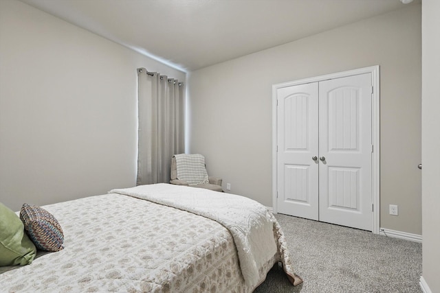 carpeted bedroom with a closet and baseboards