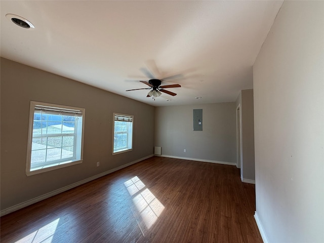 unfurnished room featuring electric panel, dark wood finished floors, and baseboards