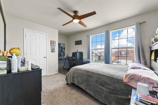 carpeted bedroom with ceiling fan and baseboards