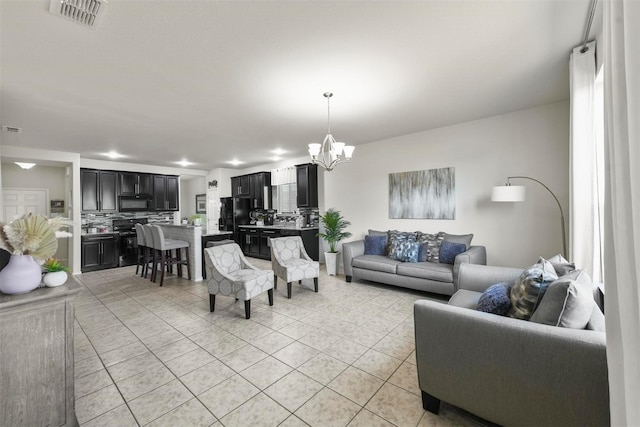 living room with a chandelier, light tile patterned floors, and visible vents