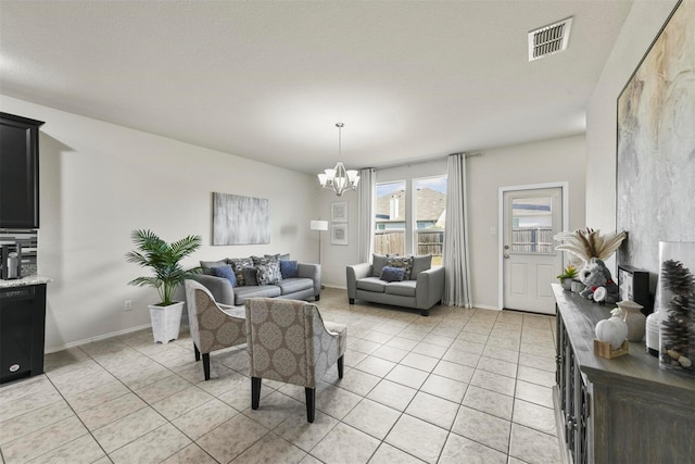 living room with a chandelier, light tile patterned flooring, visible vents, and baseboards