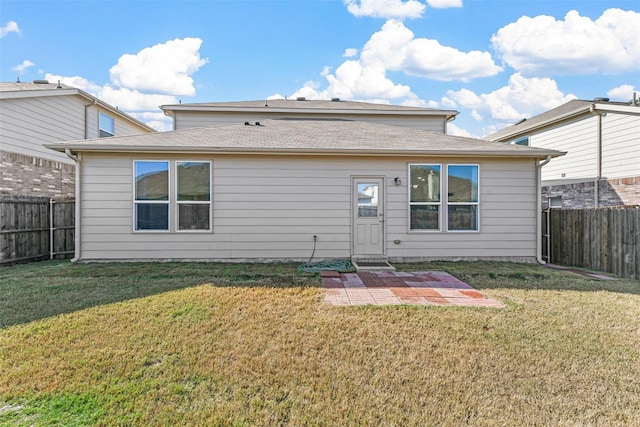 rear view of property with a fenced backyard, a lawn, and a patio