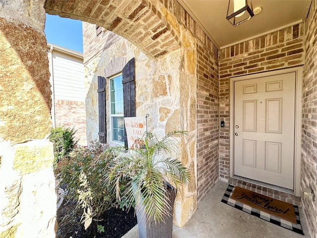 view of exterior entry featuring brick siding