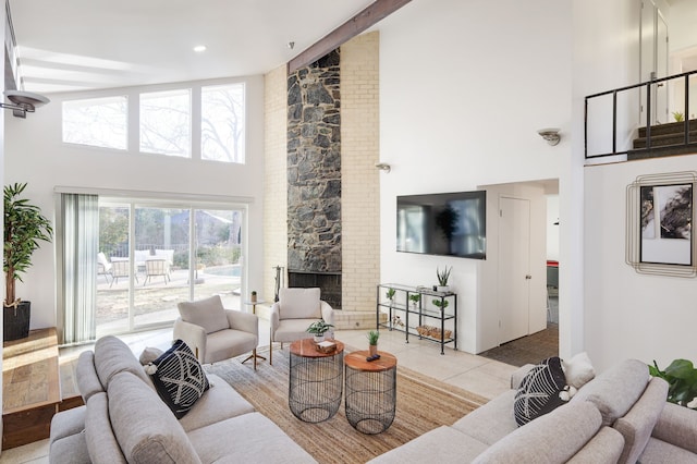 tiled living room with a high ceiling and a stone fireplace