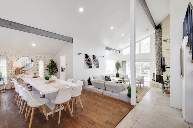 dining space featuring stairway, beamed ceiling, a fireplace, and recessed lighting