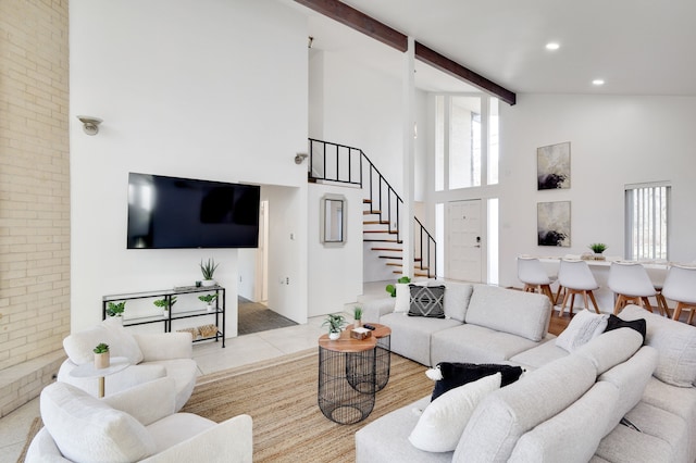 living room featuring high vaulted ceiling, a healthy amount of sunlight, beamed ceiling, and stairs