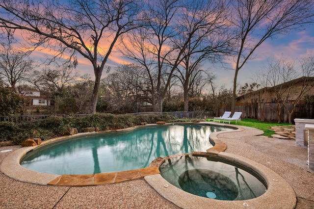 view of swimming pool featuring a fenced backyard, a pool with connected hot tub, and a patio