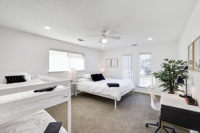 bedroom featuring a textured ceiling, ceiling fan, carpet flooring, and visible vents