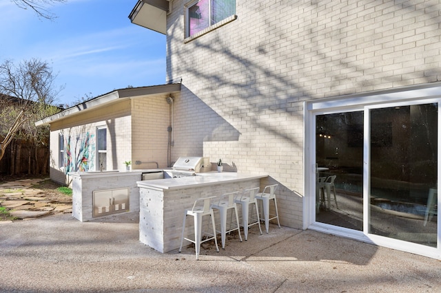 view of patio featuring outdoor wet bar, grilling area, and area for grilling