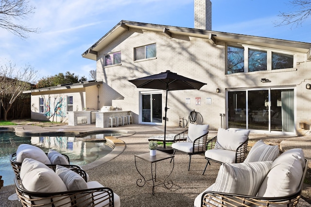 back of property featuring an outdoor hangout area, a patio, brick siding, and a chimney