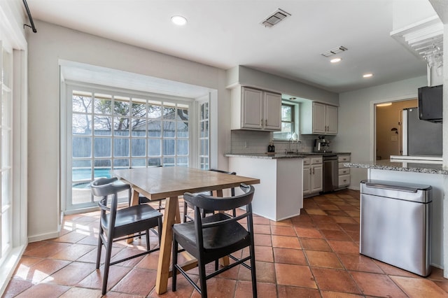 kitchen with visible vents, recessed lighting, freestanding refrigerator, and decorative backsplash