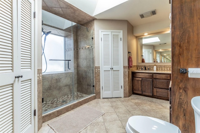 full bath with vanity, visible vents, a shower stall, a closet, and toilet