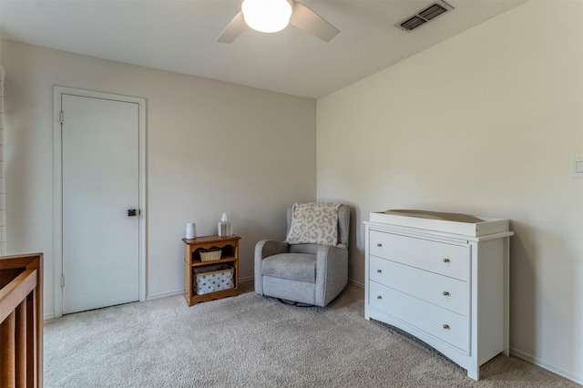 living area with visible vents, carpet floors, and ceiling fan