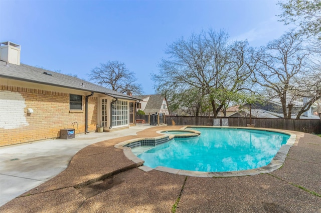 view of swimming pool featuring a pool with connected hot tub, a patio area, and a fenced backyard