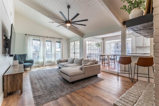 living room with a ceiling fan, wooden ceiling, vaulted ceiling with beams, and light wood finished floors