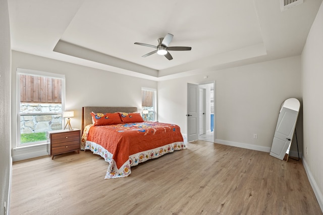 1607 Amesbury Ln, Rockwall, TX 75087 - bedroom featuring a raised ceiling, light wood-style floors, baseboards, and a ceiling fan