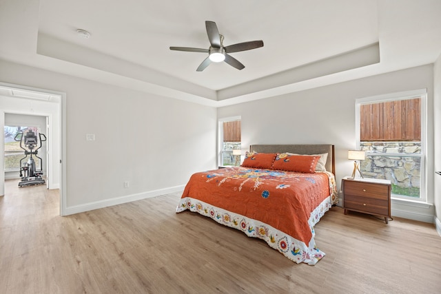 1607 Amesbury Ln, Rockwall, TX 75087 - bedroom with a tray ceiling, attic access, light wood-type flooring, and baseboards
