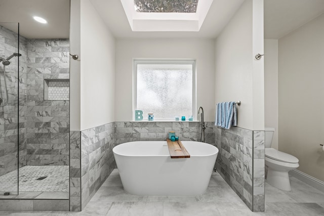 1607 Amesbury Ln, Rockwall, TX 75087 - bathroom featuring a soaking tub, a shower stall, tile walls, toilet, and wainscoting