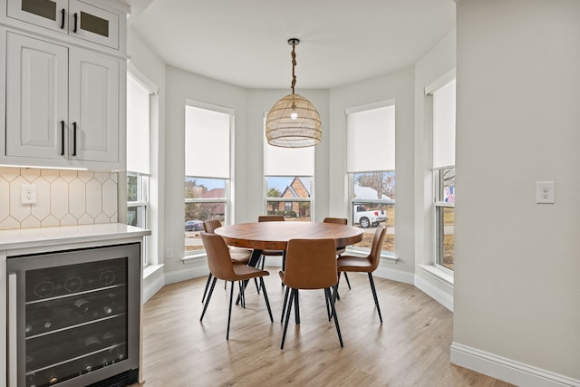 1607 Amesbury Ln, Rockwall, TX 75087 - dining area with wine cooler, baseboards, and light wood-style floors