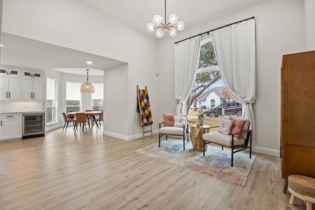 1607 Amesbury Ln, Rockwall, TX 75087 - sitting room featuring wine cooler, plenty of natural light, light wood-style flooring, baseboards, and a towering ceiling