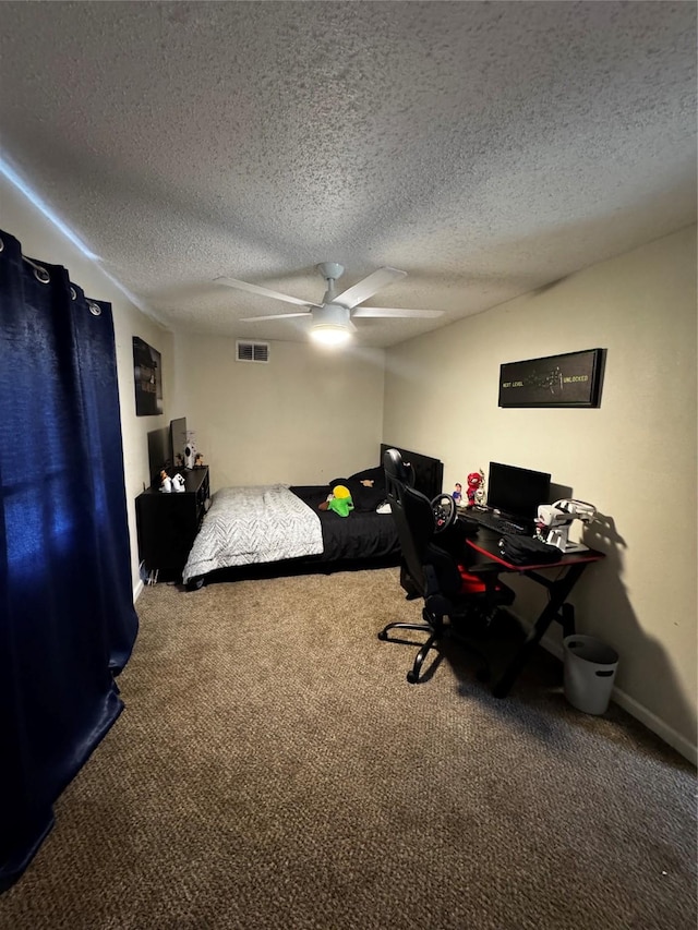 bedroom featuring carpet floors, visible vents, ceiling fan, and a textured ceiling