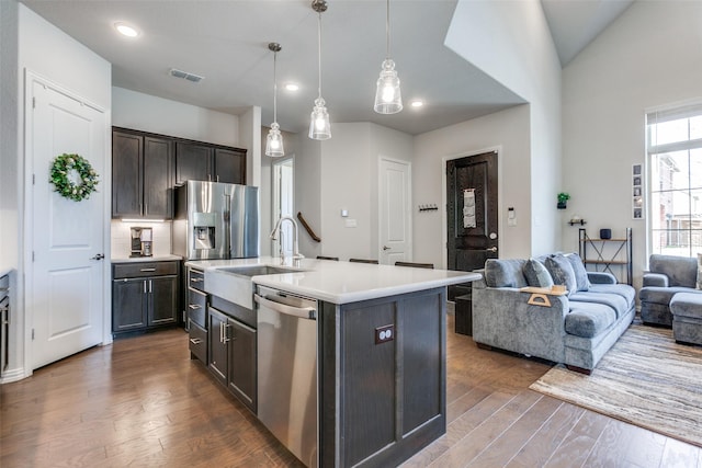 kitchen featuring a sink, light countertops, open floor plan, and stainless steel appliances