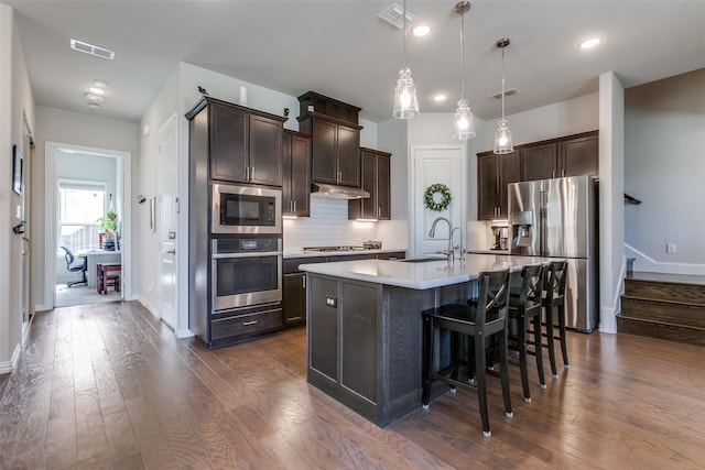 kitchen with visible vents, dark brown cabinets, stainless steel appliances, and a sink