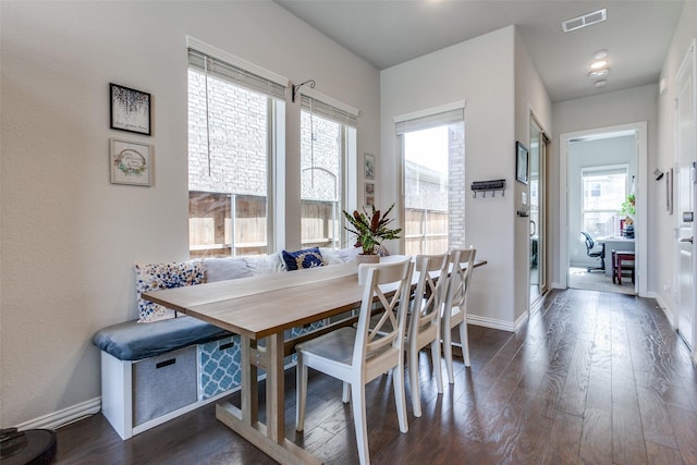 dining area featuring visible vents, baseboards, and dark wood-style floors