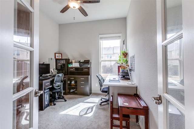 carpeted office space featuring a textured wall and ceiling fan