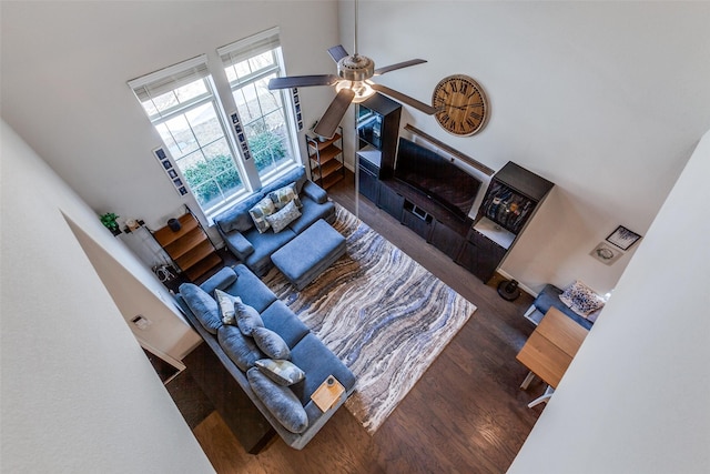 living area featuring ceiling fan, wood finished floors, and high vaulted ceiling