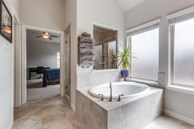 ensuite bathroom with a wealth of natural light, lofted ceiling, ensuite bathroom, and a garden tub