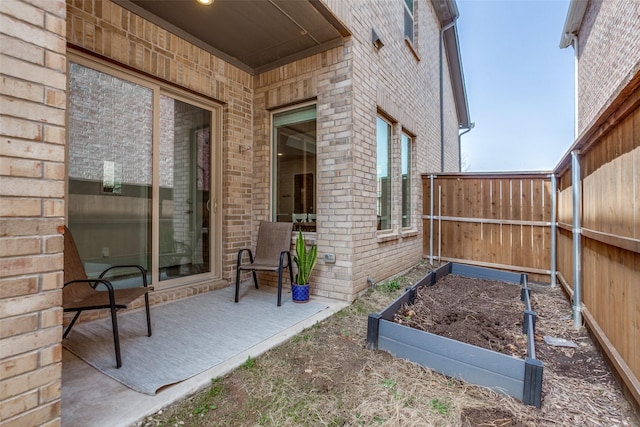 view of patio / terrace with a vegetable garden and fence