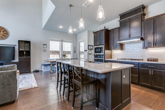 kitchen with visible vents, dark wood-style flooring, light countertops, appliances with stainless steel finishes, and tasteful backsplash