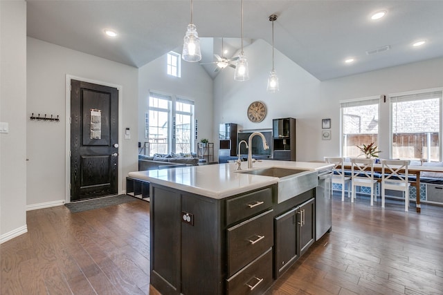 kitchen featuring visible vents, a sink, light countertops, dishwasher, and dark wood-style flooring