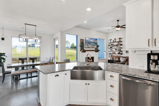 kitchen with dishwasher, light stone counters, a sink, and white cabinetry