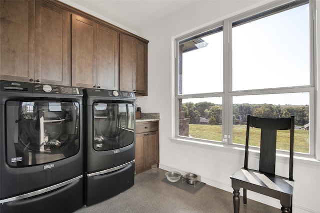 washroom with separate washer and dryer, cabinet space, and baseboards