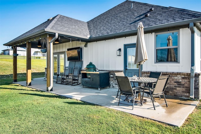 back of house featuring a shingled roof, french doors, a yard, and a patio