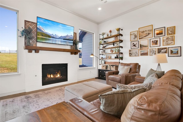 living room featuring recessed lighting, visible vents, baseboards, a glass covered fireplace, and crown molding