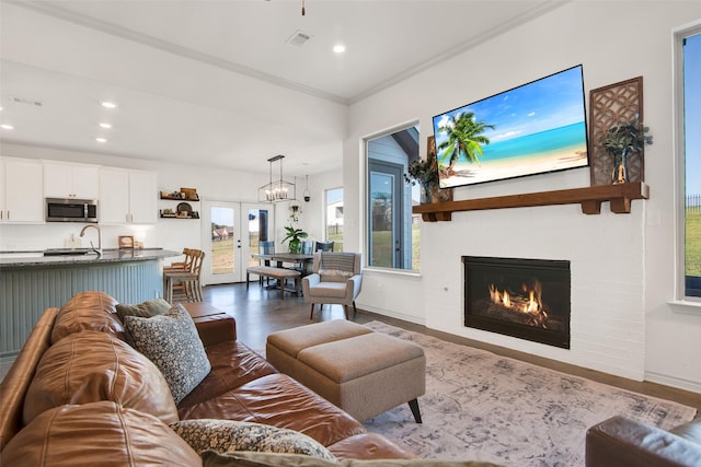 living room with recessed lighting, a fireplace, visible vents, and ornamental molding