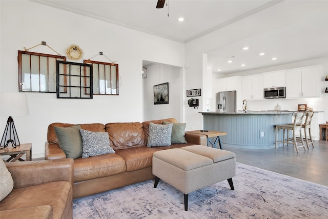 living room featuring concrete flooring, recessed lighting, ceiling fan, and ornamental molding