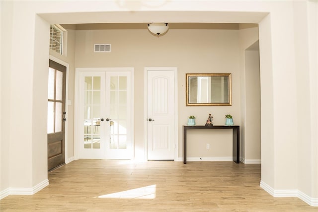 interior space featuring french doors, visible vents, baseboards, and light wood finished floors