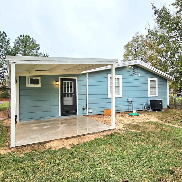 rear view of property featuring a lawn, a patio area, and central air condition unit