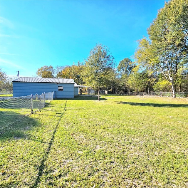 view of yard featuring fence, an outdoor structure, and an outbuilding