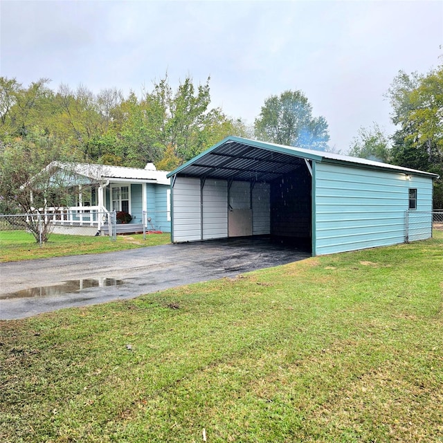 view of outbuilding with driveway and a carport