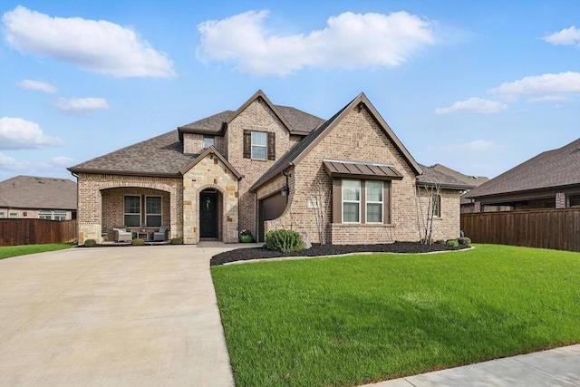 2813 Carrington Dr, Mansfield, TX 76063 - french country style house featuring brick siding, fence, concrete driveway, and an attached garage