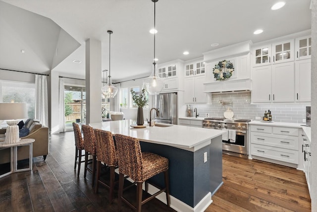2813 Carrington Dr, Mansfield, TX 76063 - kitchen featuring a sink, a center island with sink, dark wood-type flooring, a breakfast bar, and appliances with stainless steel finishes