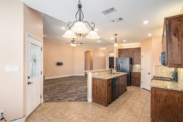 136 Clara Lee Ln, Springtown, TX 76082 - kitchen with arched walkways, tasteful backsplash, ceiling fan, an island with sink, and a sink