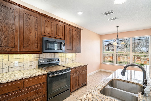 136 Clara Lee Ln, Springtown, TX 76082 - kitchen with range with electric stovetop, stainless steel microwave, a sink, light tile patterned floors, and decorative backsplash